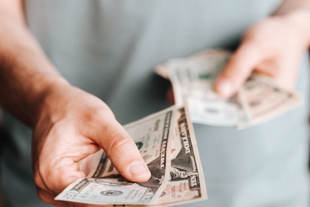 Free Crop man paying with American dollars Stock Photo